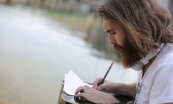 hombre con camisa blanca escribiendo en un papel
