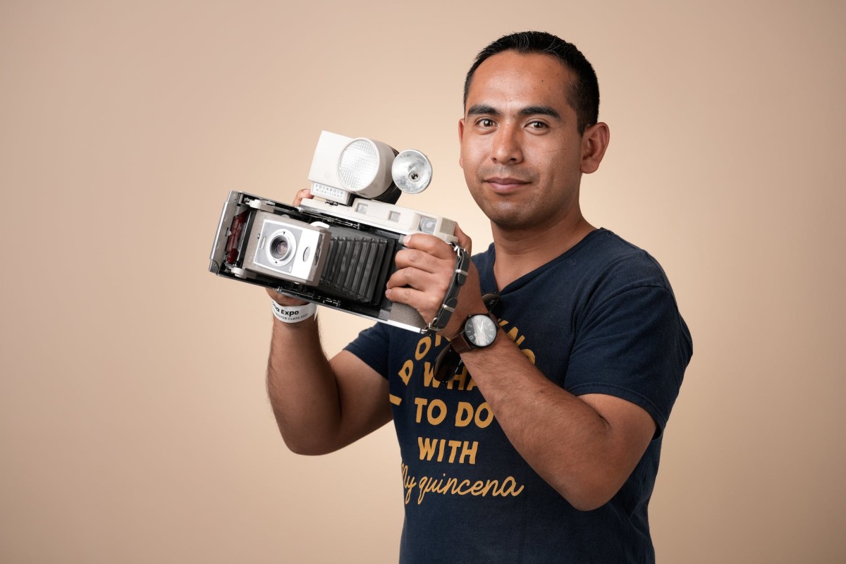portrait of man holding retro camera