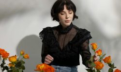 mujer en el suelo cerca de flores en jarrones